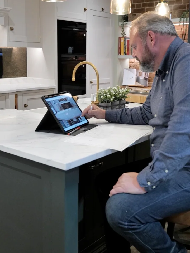 Richard Jackson reviewing a 3D kitchen design on a tablet in the showroom